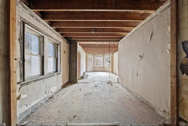 a view of a hallway with wooden floor and entryway