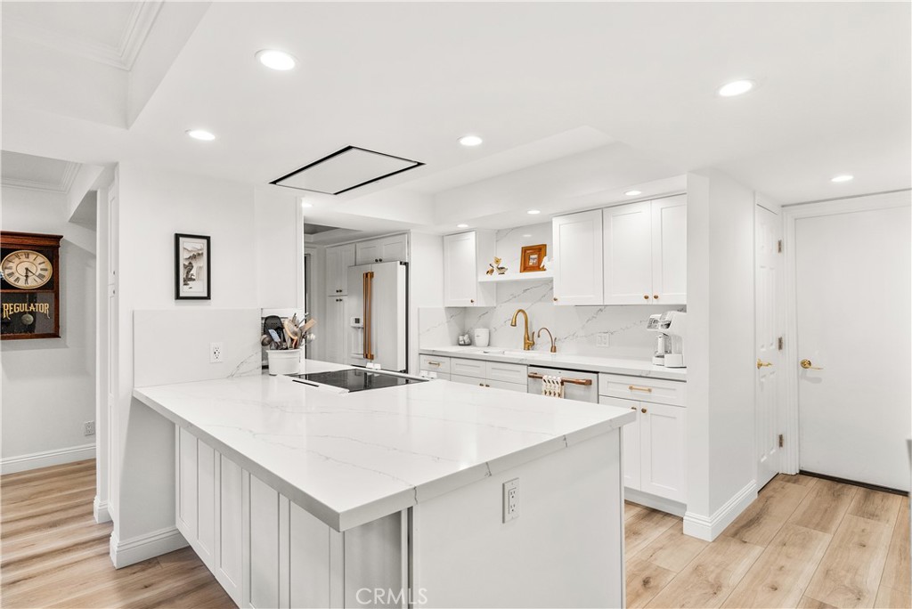 5 Canal Circle Newport Beach, CA 92663 - Photo 3 of 30 a kitchen with a sink a stove a refrigerator and white cabinets with wooden floor