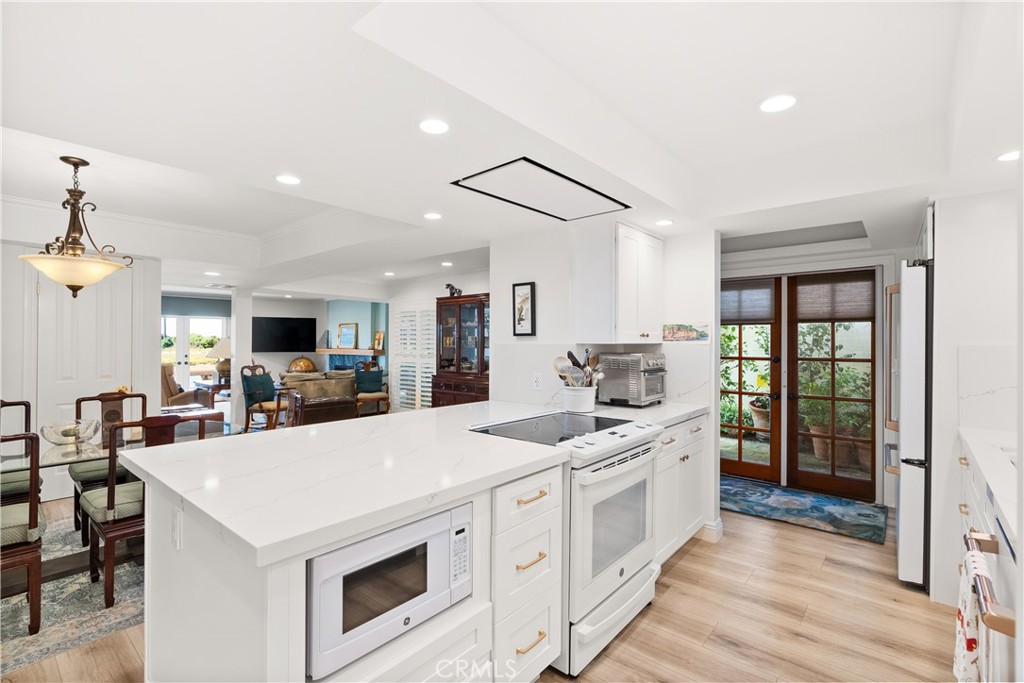 5 Canal Circle Newport Beach, CA 92663 - Photo 6 of 30 a kitchen that has a lot of white cabinets and wooden floor