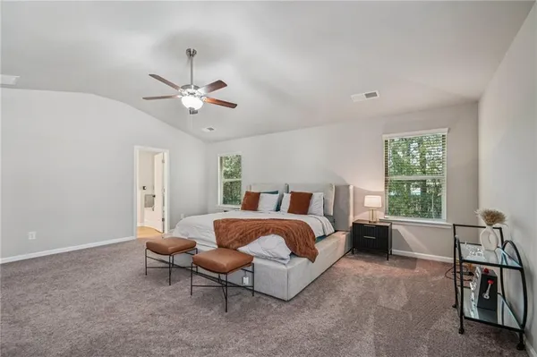 a spacious bedroom with a bed and a chandelier