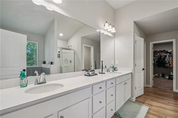 a bathroom with double vanity sinks a vanity a lamp and a mirror
