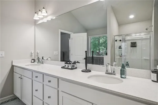 a bathroom with double vanity sinks double vanity tub shower and a mirror