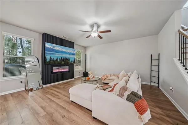 a living room with furniture floor to ceiling window and a flat screen tv