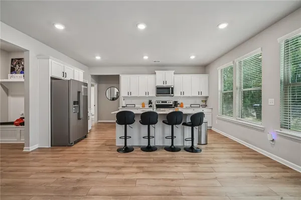 a kitchen with stainless steel appliances kitchen island granite countertop a refrigerator and a stove top oven