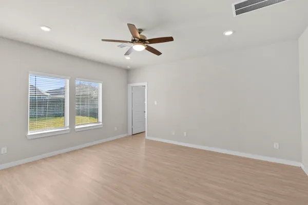 a view of a room with wooden floor and a ceiling fan
