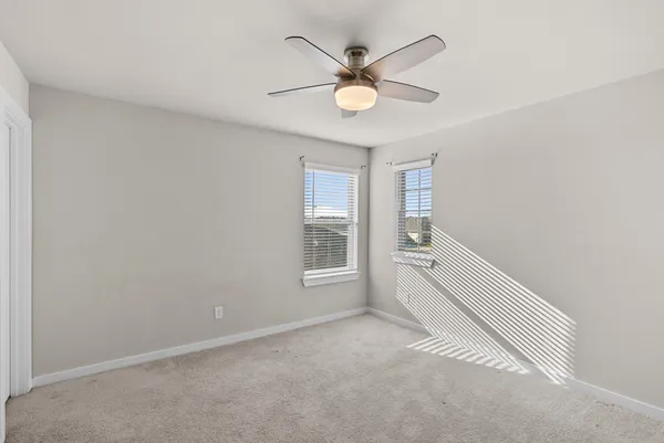 an empty room with a fan and a fan