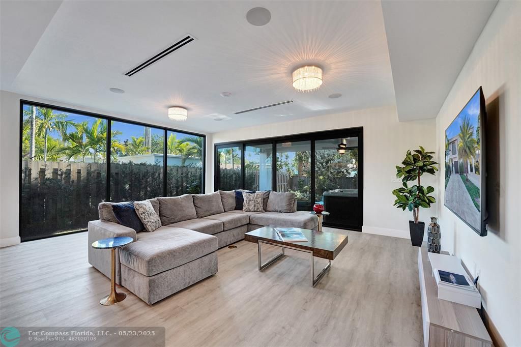 1238 Northeast 17th Avenue, Unit 2 Fort Lauderdale, FL 33304 - Photo 11 of 40 a living room with furniture large window and flat screen tv