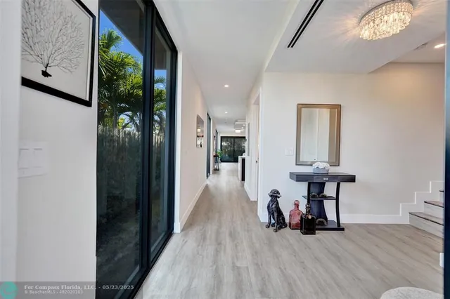 a view of a hallway with wooden floor and furniture