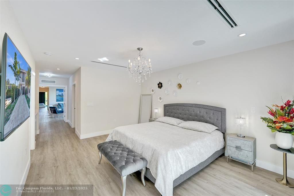 1238 Northeast 17th Avenue, Unit 2 Fort Lauderdale, FL 33304 - Photo 22 of 40 a bedroom with a bed and a chandelier