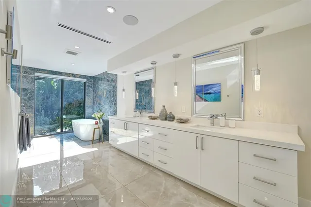 a spacious bathroom with a double vanity sink mirror and shower