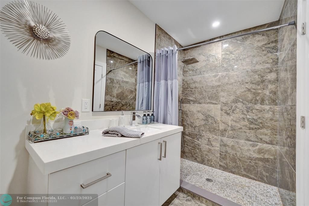 1238 Northeast 17th Avenue, Unit 2 Fort Lauderdale, FL 33304 - Photo 31 of 40 a bathroom with a sink and a mirror