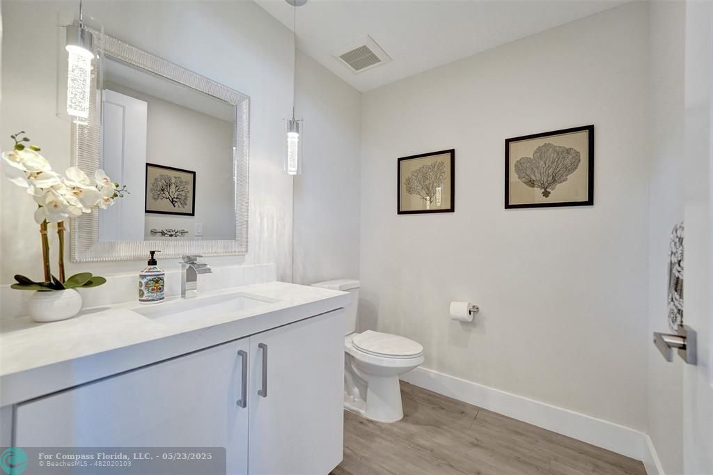 1238 Northeast 17th Avenue, Unit 2 Fort Lauderdale, FL 33304 - Photo 36 of 40 a bathroom with a toilet a sink a mirror and vanity