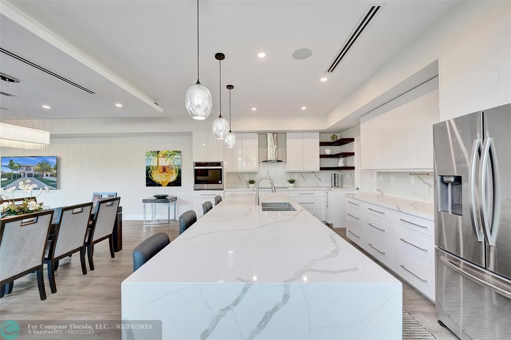 1238 Northeast 17th Avenue, Unit 2 Fort Lauderdale, FL 33304 - Photo 4 of 40 a large kitchen with stainless steel appliances kitchen island a table chairs refrigerator and a sink