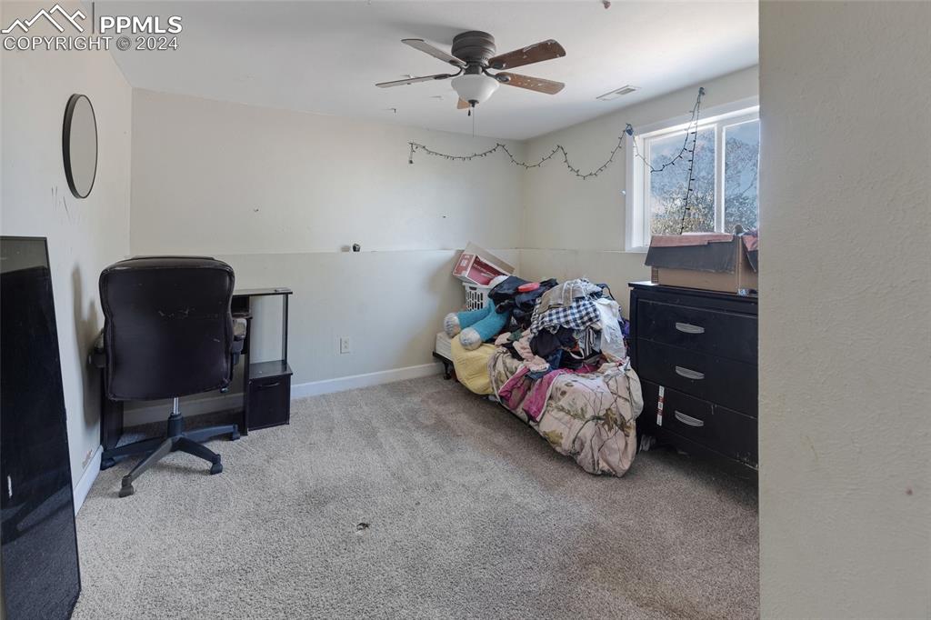 36865 Funk Road Calhan, CO 80808 - Photo 18 of 21 a bedroom with a bed and a chandelier