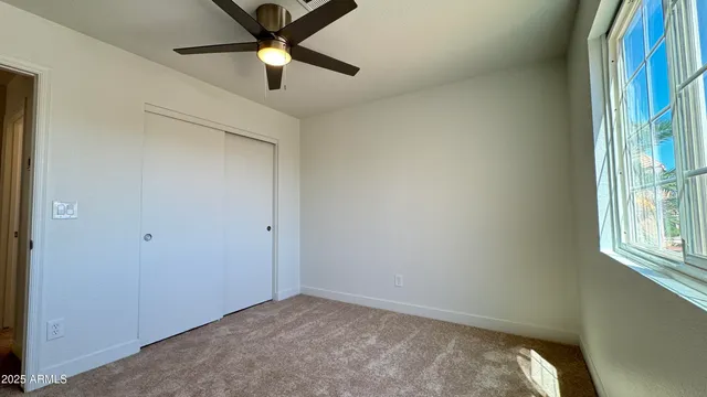 a view of a room with a ceiling fan and a window
