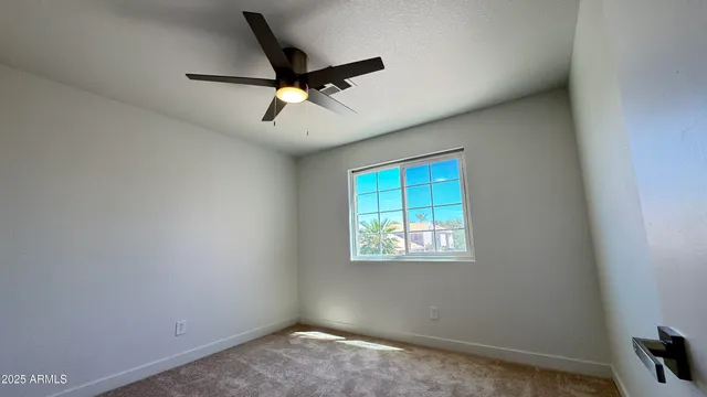 an empty room with a window and a fan