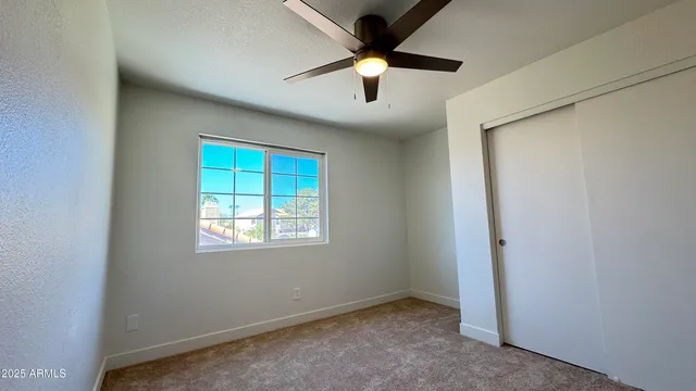 an empty room with windows and cabinet