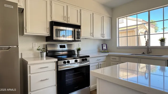 a kitchen with granite countertop white cabinets stainless steel appliances and a sink