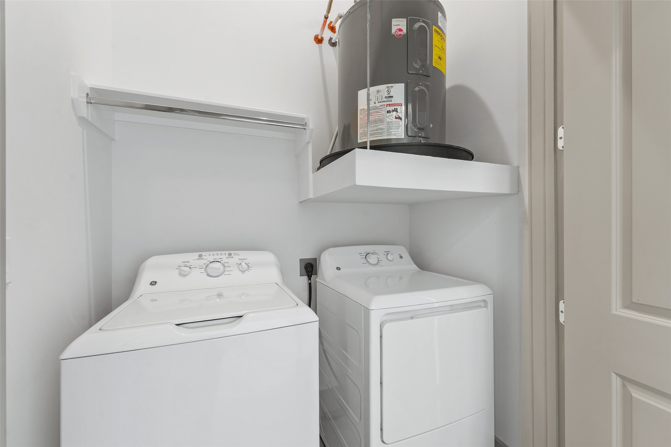 170 Malone Street, Unit 3401 Houston, TX 77007 - Photo 7 of 28 Laundry area with a washer and dryer side by side, and a shelf above the dryer to organize your cleaning supplies. The space is clean, functional, and efficiently organized.