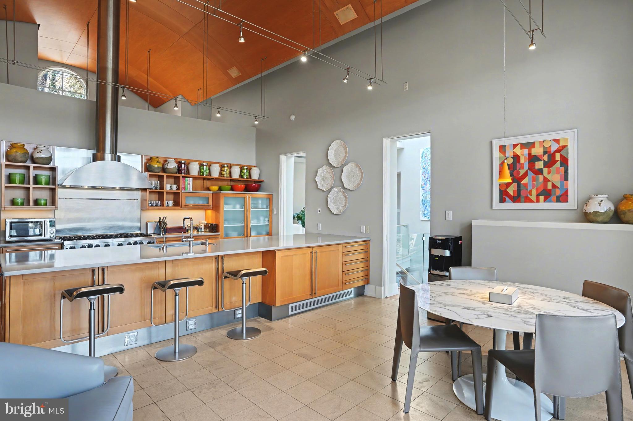 1100 Crest Lane McLean, VA 22101 - Photo 16 of 49 a kitchen with stainless steel appliances kitchen island granite countertop a table chairs in it and wooden floors