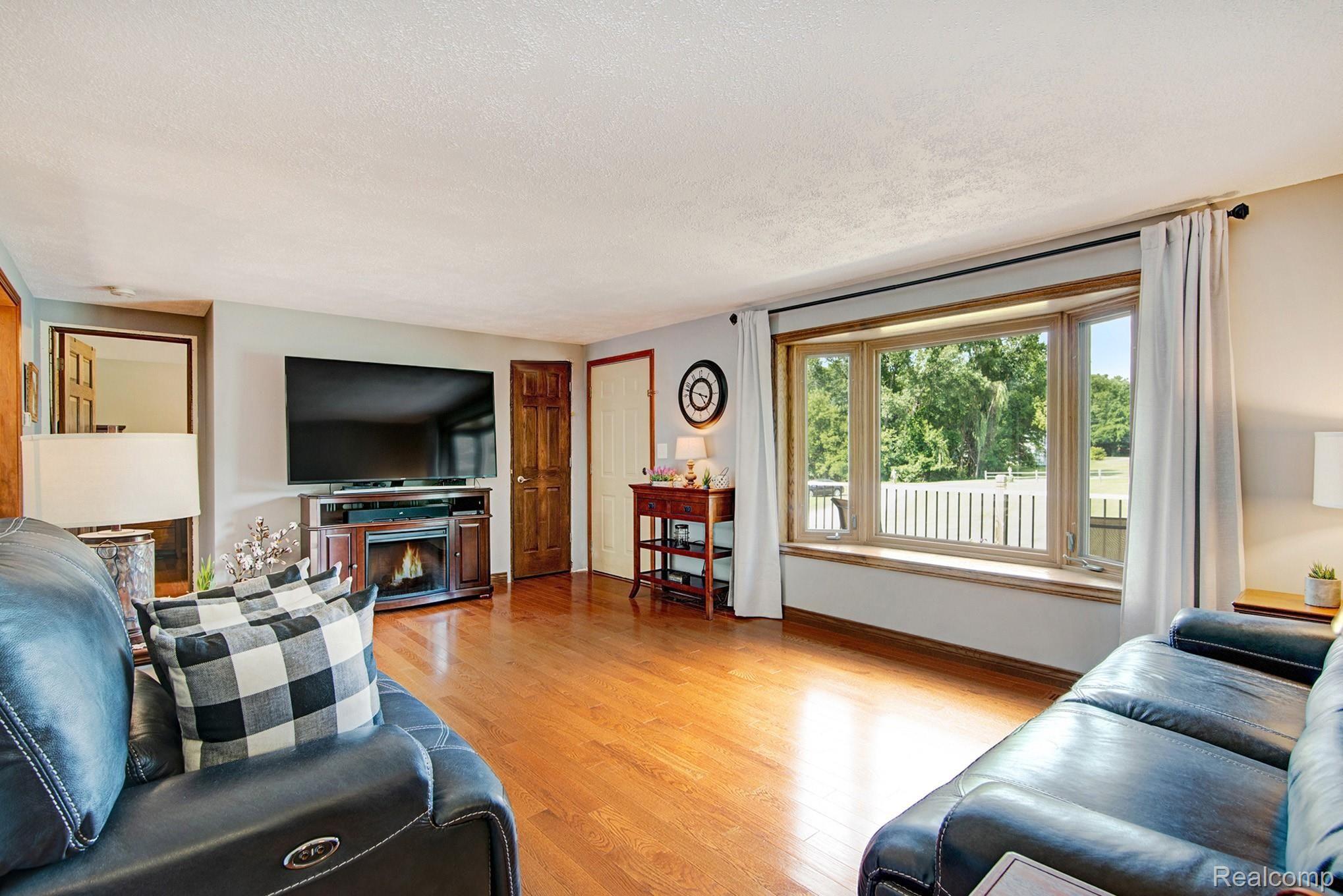 6671 North Fowlerville Road Fowlerville, MI 48836 - Photo 8 of 27 Living room area with wood floors and bay window