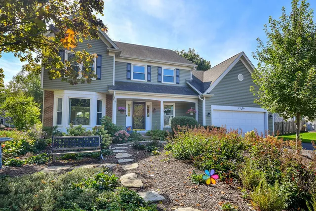 a front view of a house with a yard and fountain