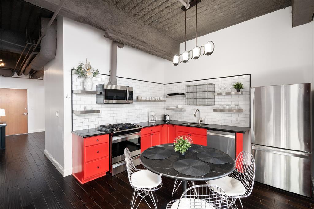 511 North Akard Street, Unit 1502 Dallas, TX 75201 - Photo 7 of 30 Kitchen featuring red cabinetry, granite countertops, stainless steel appliances, open shelves, and a sink