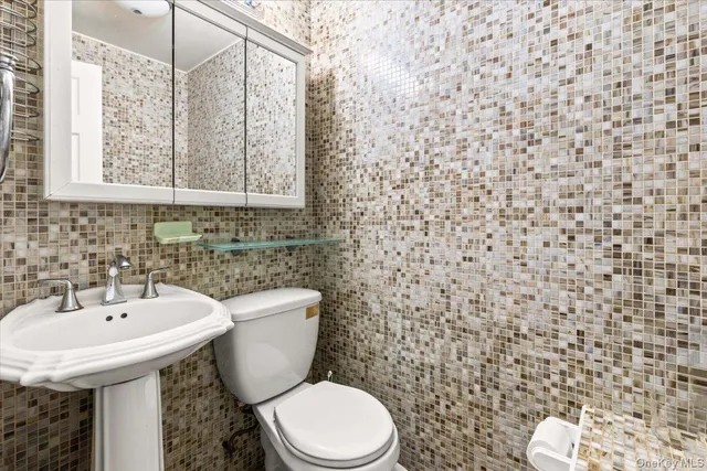 a bathroom with a toilet sink and mirror