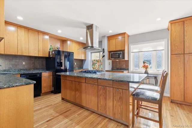 a kitchen with stainless steel appliances granite countertop a stove a sink and a refrigerator