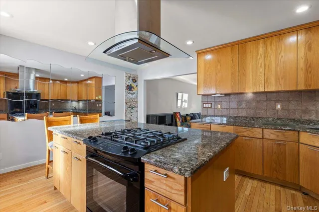 a kitchen that has a sink a stove and a wooden cabinets