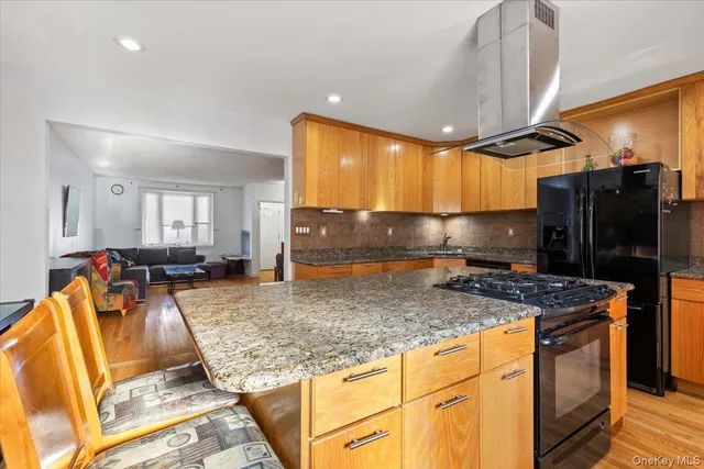 a kitchen with stainless steel appliances granite countertop a sink a stove and a refrigerator