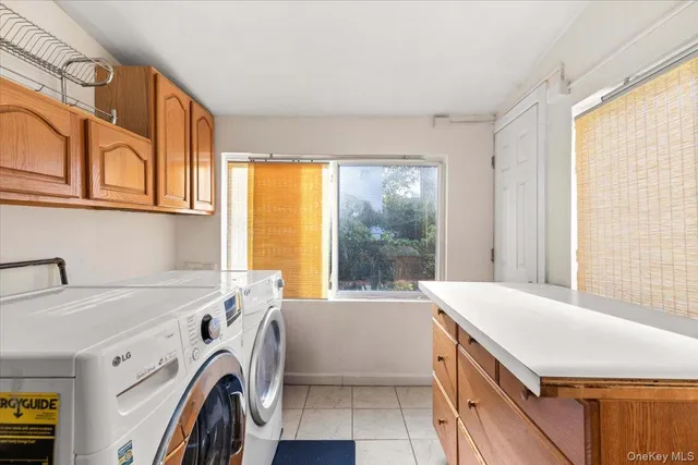 a utility room with a sink a washer and dryer next to a window