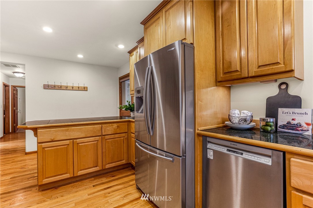 17418 Southeast 106th Street Renton, WA 98059 - Photo 14 of 39 a kitchen with stainless steel appliances granite countertop a refrigerator and a sink