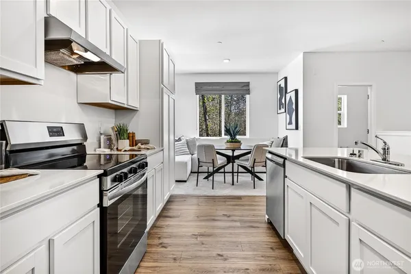 a kitchen with stainless steel appliances a stove a sink and cabinets