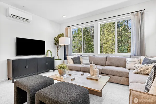 a living room with furniture a flat screen tv and a floor to ceiling window
