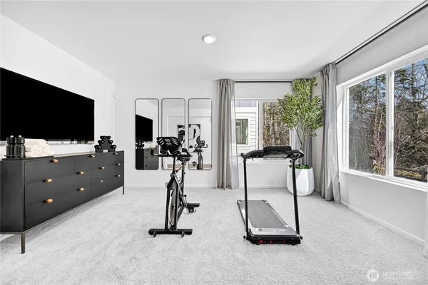 a room with gym equipment and a flat screen tv