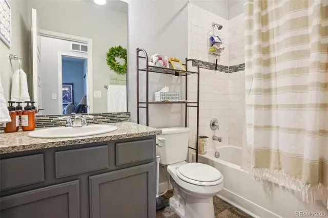 a bathroom with a granite countertop toilet sink and mirror