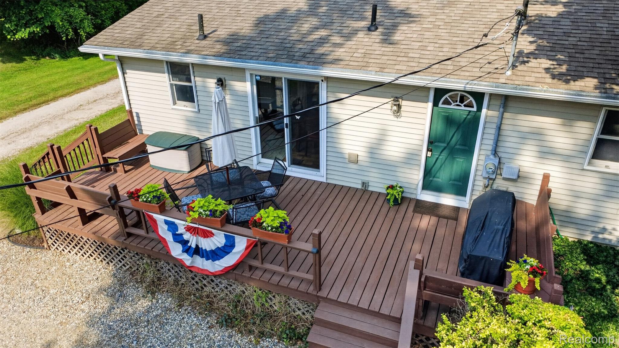 5977 Anglers Road Ortonville, MI 48462 - Photo 46 of 63 Spacious rear deck featuring wood-finish flooring, built-in benches, and direct access through a sliding glass door