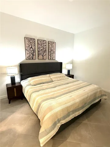 a large bed sitting in a bedroom and a table