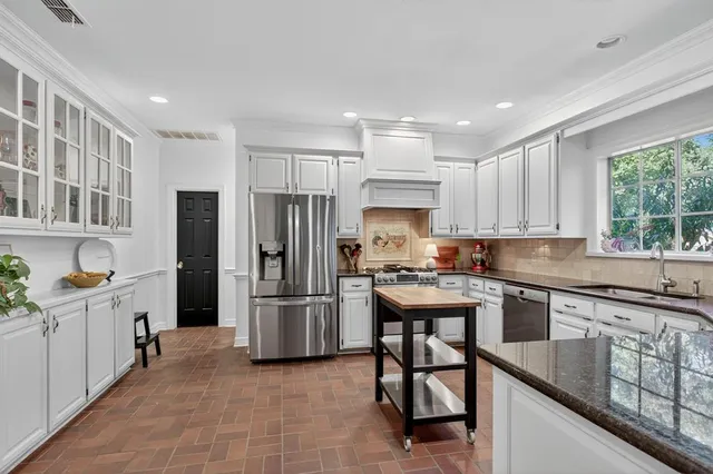 a kitchen with stainless steel appliances granite countertop a refrigerator sink and cabinets