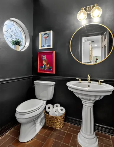 a bathroom with a toilet a sink and a mirror