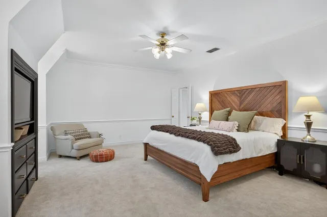 a spacious bedroom with a bed and a chandelier