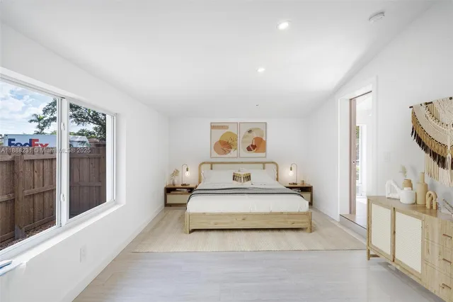 a spacious bedroom with a bed and a flat screen tv