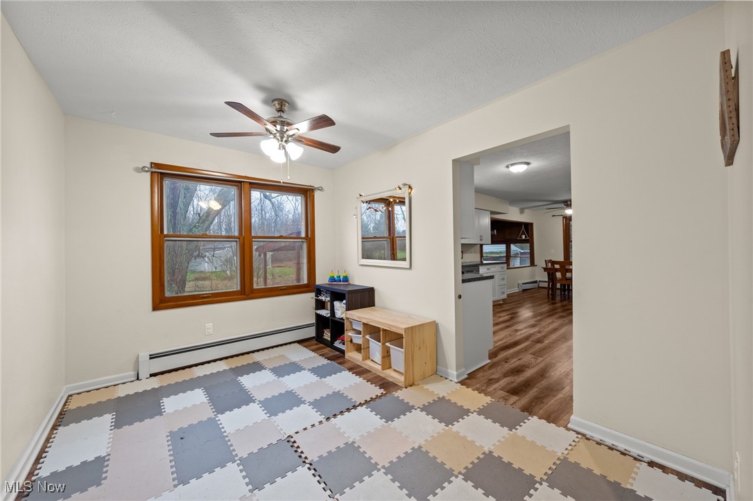 24659 Snell Road Columbia Station, OH 44028 - Photo 9 of 39 Empty room with light hardwood / wood-style flooring, ceiling fan, and a baseboard heating unit