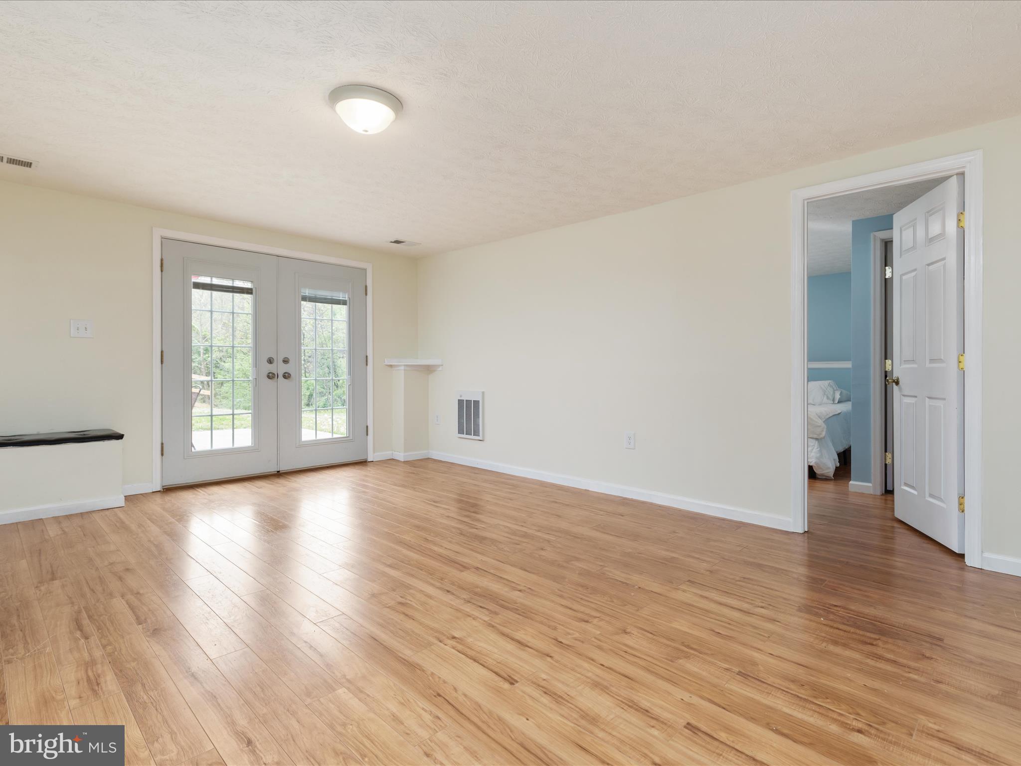 838 Dollar Lane Bunker Hill, WV 25413 - Photo 19 of 68 a view of an empty room with wooden floor and a window