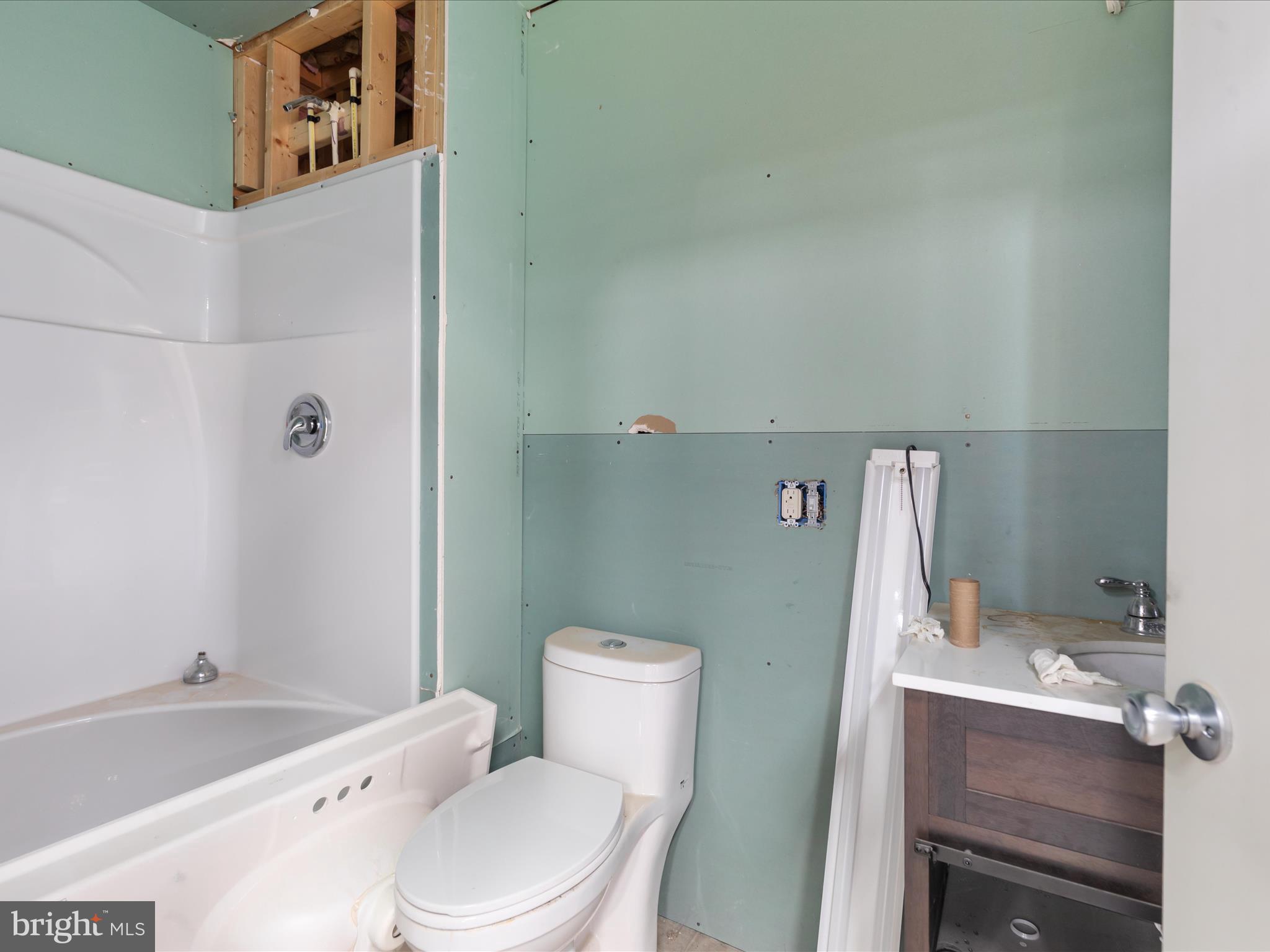 838 Dollar Lane Bunker Hill, WV 25413 - Photo 54 of 68 a white toilet sitting next to a bathroom sink and tub