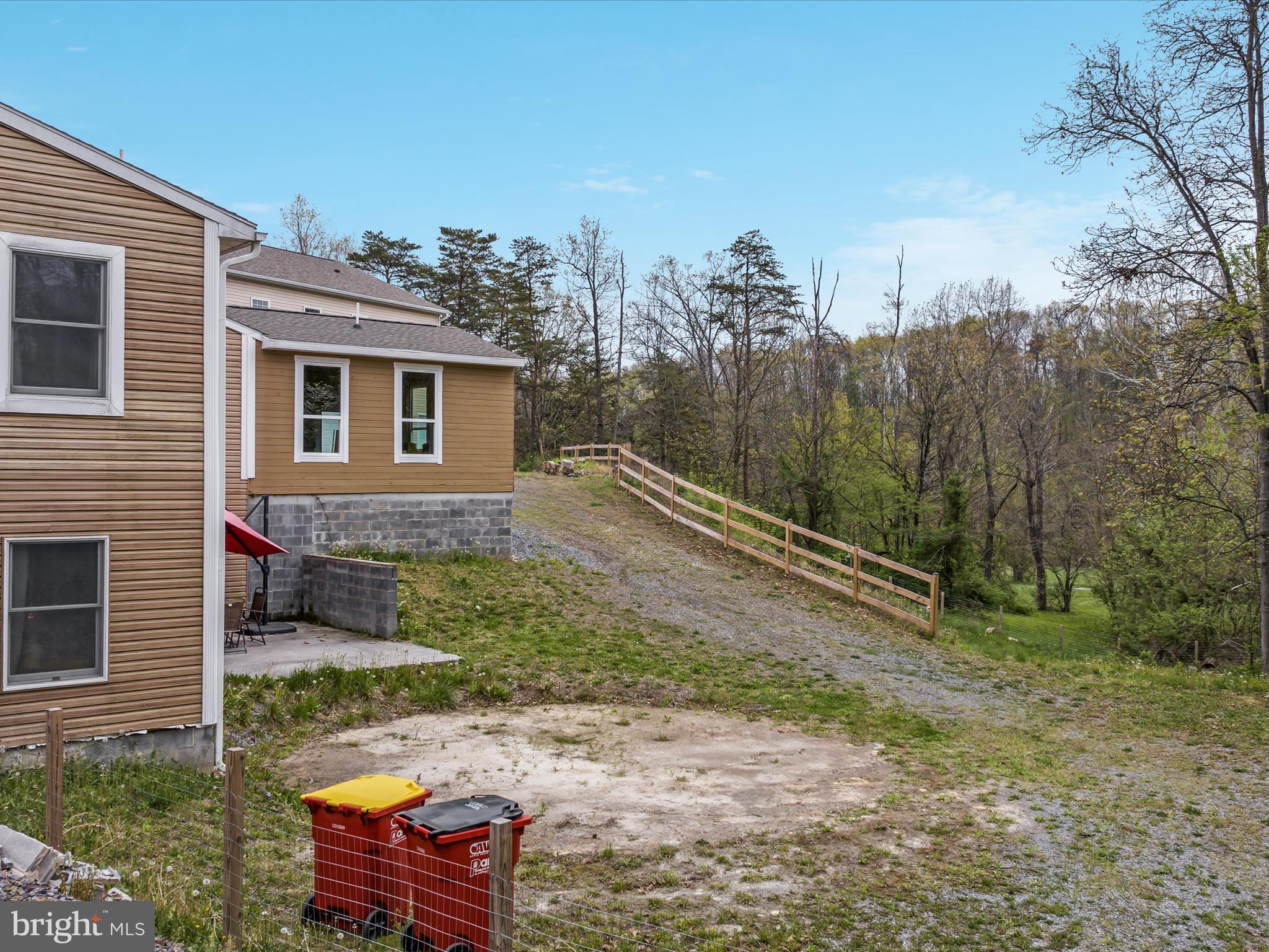 838 Dollar Lane Bunker Hill, WV 25413 - Photo 61 of 68 a backyard of a house with large trees and wooden fence