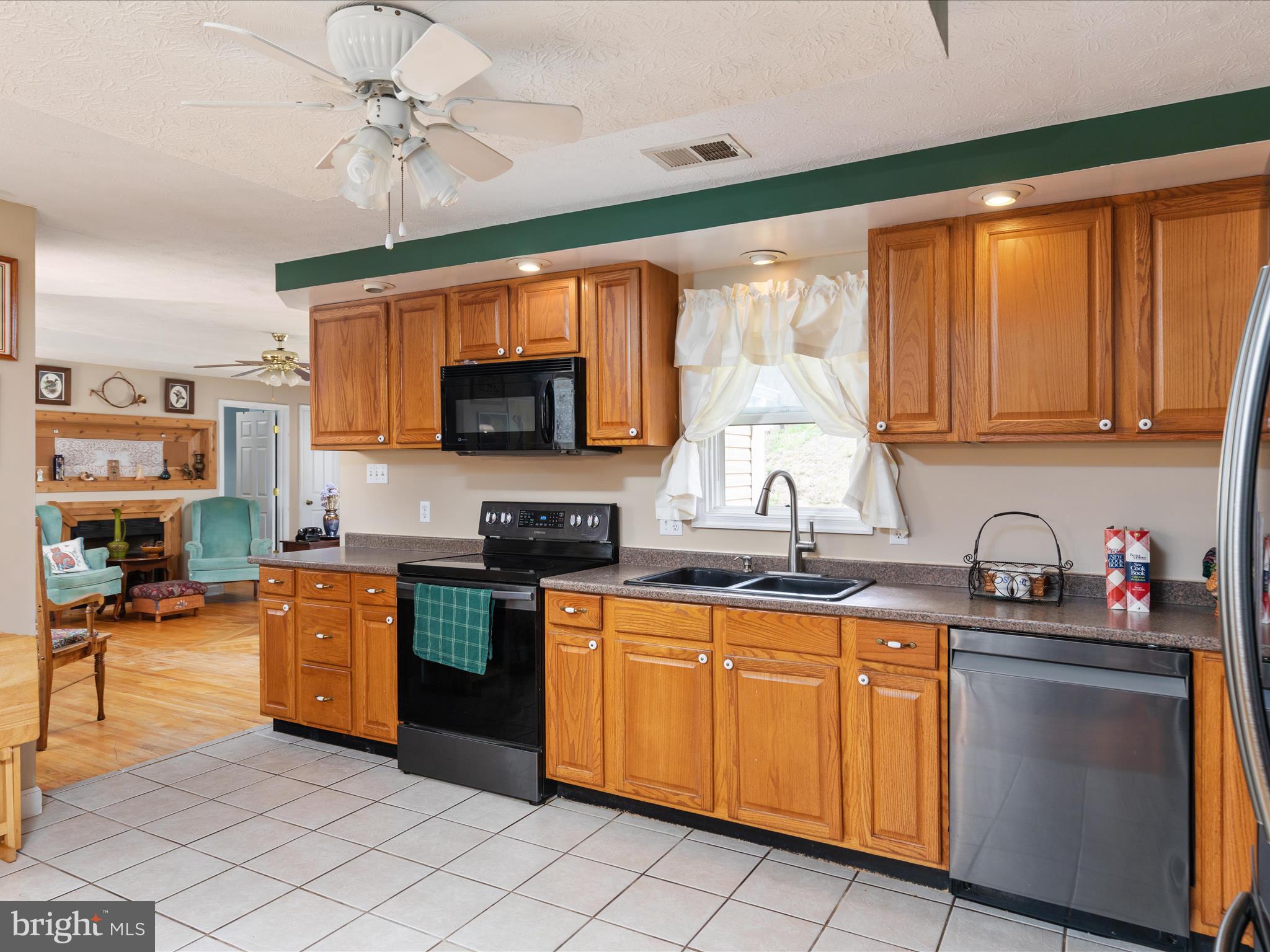 838 Dollar Lane Bunker Hill, WV 25413 - Photo 10 of 68 a kitchen with stainless steel appliances granite countertop a sink dishwasher stove top oven and cabinets with wooden floor