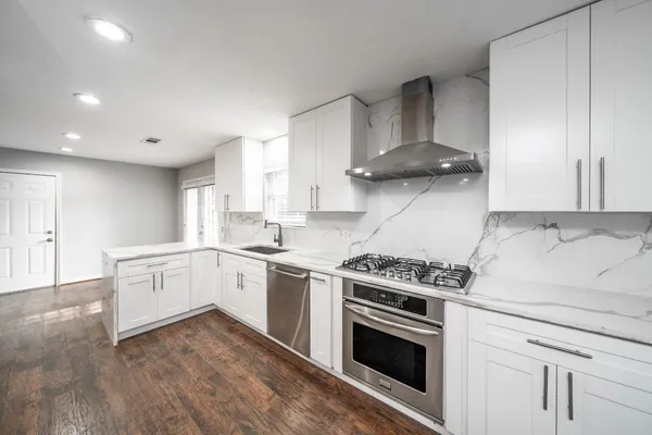 a kitchen with a stove oven and white cabinets