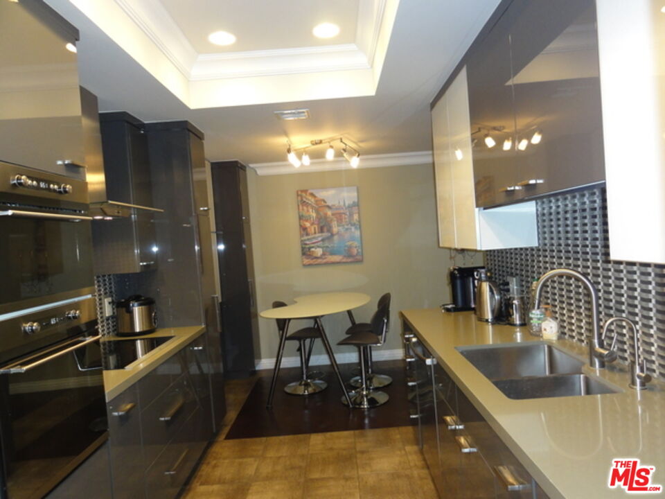 1880 Veteran Avenue, Unit 107 Los Angeles, CA 90025 - Photo 6 of 26 a kitchen with stainless steel appliances kitchen island granite countertop a sink and cabinets